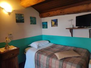 a bedroom with a bed and a tv on the wall at D'elite Apartment in Ferrara