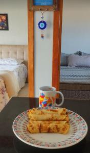 une assiette de nourriture sur une table avec une tasse de café dans l'établissement Residencial Caravelle, à Passo de Torres