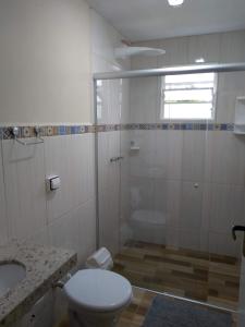 a bathroom with a shower and a toilet and a sink at Pousada Recanto do Sossego in São Thomé das Letras