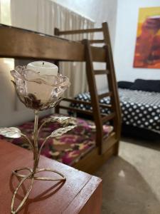 Una vela sentada en una mesa junto a una cama en Habitación Familiar. El Arroyo en Paraguarí