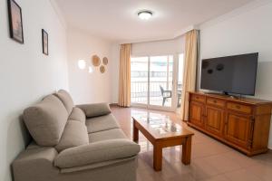 a living room with a couch and a flat screen tv at Apartamentos Solset Nerja in Nerja