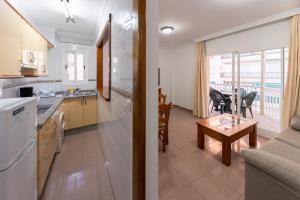 a kitchen and a living room with a table at Apartamentos Solset Nerja in Nerja