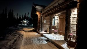 a log cabin in the snow at night at Liaplassen Tømmerhytte in Beitostøl