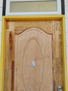 una porta del garage in legno con il numero quattro sopra. di KUNDASANG MOUNT GARDEN a Kampong Kundassan