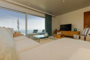 a living room with a bed and a television at Villa Harmonia by Place OverSea With Indoor Pool in Ponta do Sol