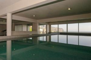 a swimming pool in a building with a view of the water at Villa Harmonia by Place OverSea With Indoor Pool in Ponta do Sol