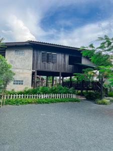 a building with a fence in front of it at North Pine Forest Homestay บ้านไม้สนโฮมสเตย์ in Ban Mae Pong