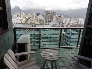 Un balcón con una silla, una mesa y una ciudad en Ipanema Tiffanys, en Río de Janeiro