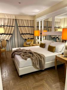 Erbavoglio Hotel في ريميني: غرفة نوم مع سرير أبيض كبير في غرفة