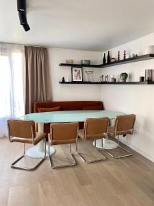 a dining room with a blue table and chairs at Le Duplex Paris Basilique Stade de France in Saint-Denis