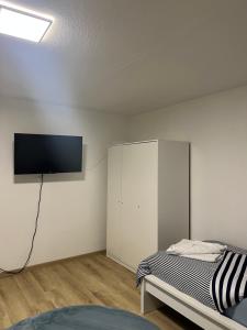 1 dormitorio con 1 cama y TV en la pared en Kiefern Apartments, en Hannover