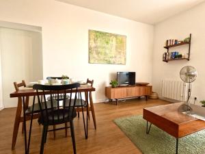 a living room with a table and a room with a tv at Peaceful & panoramic views apartment, Cascais in Cascais