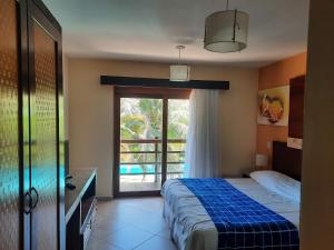 ein Schlafzimmer mit einem Bett und einem großen Fenster in der Unterkunft Apartamento 320 Praia Bonita Resort in Nísia Floresta + 34 Fotos