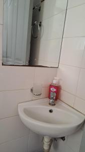 ein weißes Waschbecken im Bad mit Spiegel in der Unterkunft Zelani Hospitality in Nairobi
