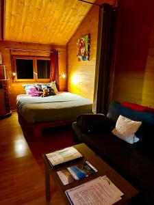 ein Wohnzimmer mit einem Bett und einem Sofa in der Unterkunft Chalet sur pilotis avec piscine privée in Lucéram