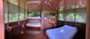 Cette petite chambre comprend 2 lits et des fenêtres. dans l'établissement Finca la Bonita, Playa Carate, à Carate
