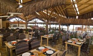 uma sala de jantar com mesas e cadeiras num resort em Apartamento 320 Praia Bonita Resort em Nísia Floresta