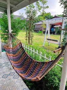 eine Hängematte, die auf einer Veranda eines Hauses hängt in der Unterkunft North Pine Forest Homestay บ้านไม้สนโฮมสเตย์ in Ban Mae Pong