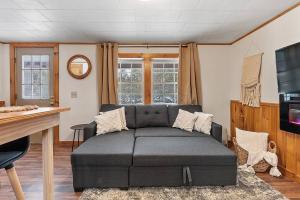 a living room with a couch and a tv at WhiteMountains Ski, Hike & Relax Retreat. 4 in Thornton