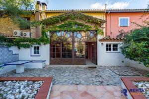 uma entrada para uma casa com uma porta grande em The Villa Jardin de Balata em Saleilles