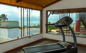 ein Raum mit einem Fitnessstudio mit Fenstern und einem Laufband in der Unterkunft Apartamento 320 Praia Bonita Resort in Nísia Floresta