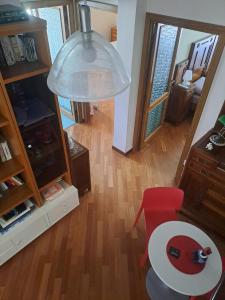ein Wohnzimmer mit einem roten Stuhl und einem Tisch in der Unterkunft B&B Corallo in Sassari