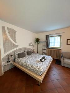 Un dormitorio con una cama con un osito de peluche. en B&B Primavera, en Spormaggiore