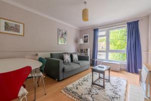 a living room with a couch and a table at Charming One Bed Abode In East Putney in London