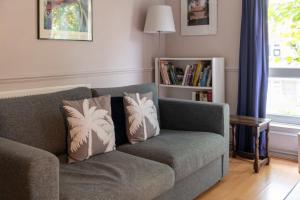 a living room with a couch and a book shelf at Charming One Bed Abode In East Putney in London