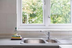 a sink in a kitchen with a window at Charming One Bed Abode In East Putney in London