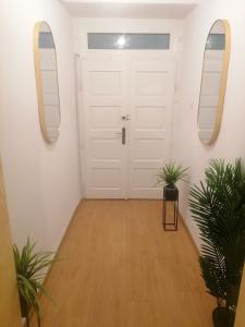 a hallway with a white door and two mirrors at Studio Excelsior 1 in Sibiu