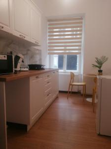 a kitchen with white cabinets and a window at Studio Excelsior 1 in Sibiu