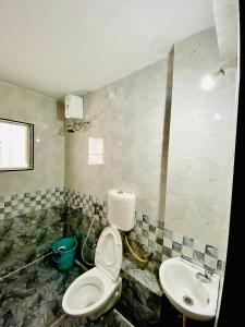a bathroom with a toilet and a sink at The Peacewood's Homes - Pune's Comfort - Hostel & PG in Pune
