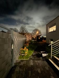einen Hinterhof in der Nacht mit einem Zaun und Blumen in der Unterkunft Kiefern Apartments in Hannover
