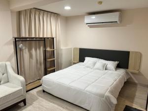 una camera con un grande letto bianco e una sedia di Touch Residence ad Al Ḩamīdīyah
