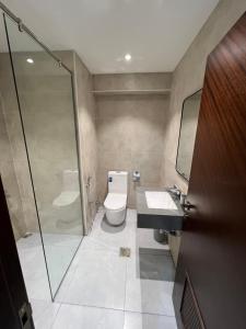 e bagno con servizi igienici, lavandino e doccia. di Touch Residence ad Al Ḩamīdīyah