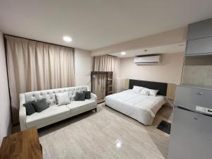 un soggiorno con 2 letti e un divano di Touch Residence ad Al Ḩamīdīyah