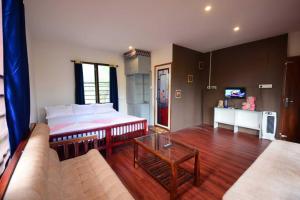 uma sala de estar com uma cama e um sofá em Greens Vista Wayanad - Premium Homestay Near Natural Stream em Panamaram