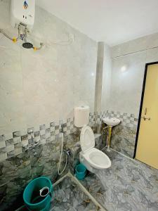 y baño con aseo y lavamanos. en The Peacewood's Homes - Pune's Comfort - Hostel & PG, en Pune