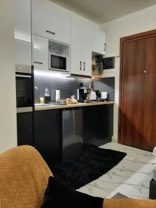 a kitchen with white cabinets and a counter top at ΑΘΗΝΑ HOME in Ioannina +23 photos