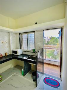 浦那的住宿－The Peacewood's Homes - Pune's Comfort - Hostel & PG，厨房配有水槽和微波炉