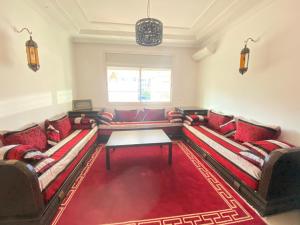 una sala de estar con 2 sofás y una alfombra roja en Full Appartement Ville Haute en Kenitra