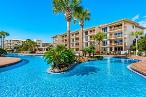 uma piscina com palmeiras em frente a um edifício em High Pointe 231 em Rosemary Beach