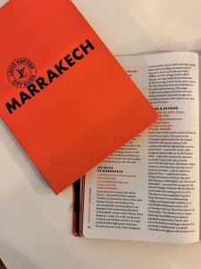 ein orangefarbenes Buch auf einem Buch in der Unterkunft Riad Les Nuits de Marrakech in Marrakesch