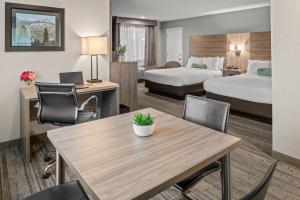 グローブランドにあるヨセミテ ウエストゲート ロッジのベッド2台、テーブルと椅子が備わるホテルルームです。