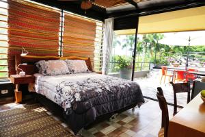 1 dormitorio con 1 cama y balcón con mesa en LALDEA Nirvana Eco Villa in Cerritos, en Pereira