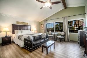 a bedroom with a bed and a couch and windows at Kronborg Inn in Solvang +24 photos
