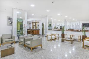 a waiting room with couches and chairs in a building at Hotel Nacional Inn Limeira in Limeira