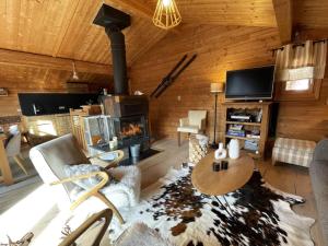 a living room with a fireplace in a log cabin at Chalet de charme 8 pers avec parking, cheminée et terrasse - Saint-Martin-de-Belleville - FR-1-452-35 in Saint-Martin-de-Belleville