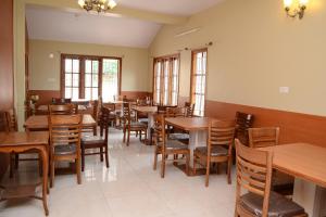 a dining room with wooden tables and chairs at Rainbow Cottages-Budget Friendly rooms in Ooty